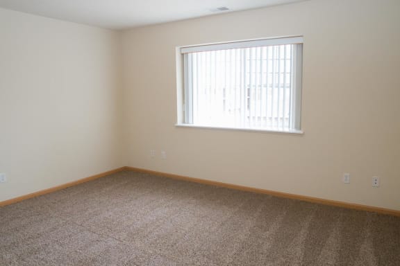 a large room with carpet and a window