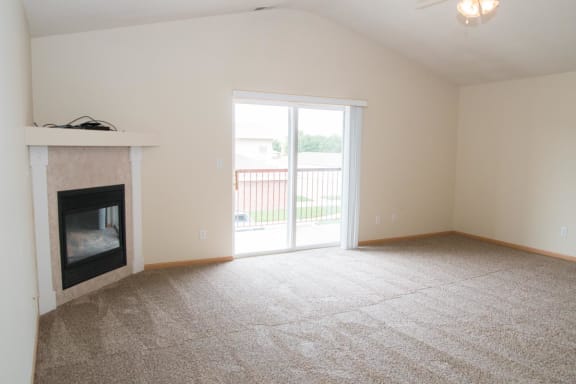 a living room with a fireplace and a door to a balcony
