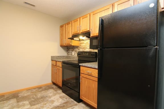 a kitchen with black appliances and wooden cabinets