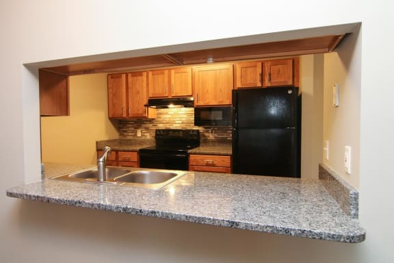 a kitchen with a granite counter top and a black refrigerator