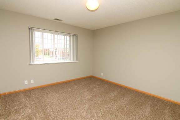 an empty room with carpet and a window
