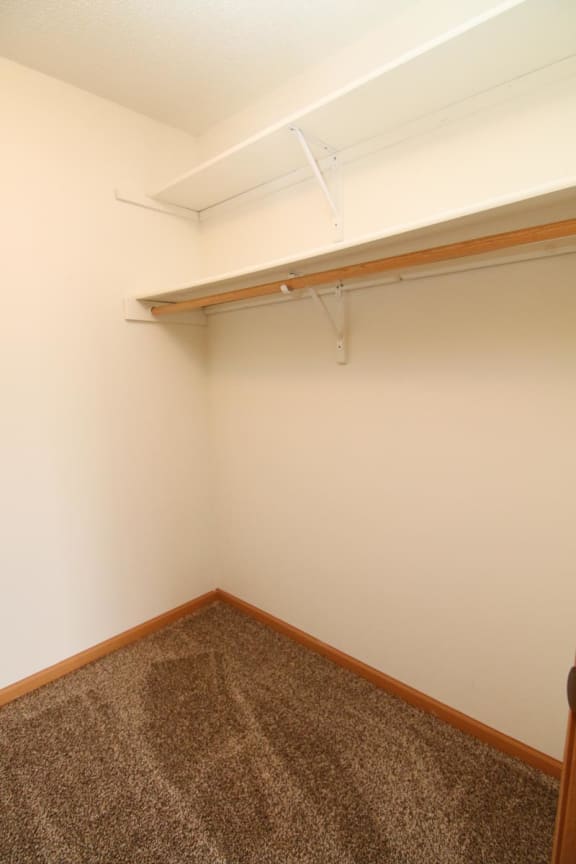 a room with a carpeted floor and a shelf on the wall