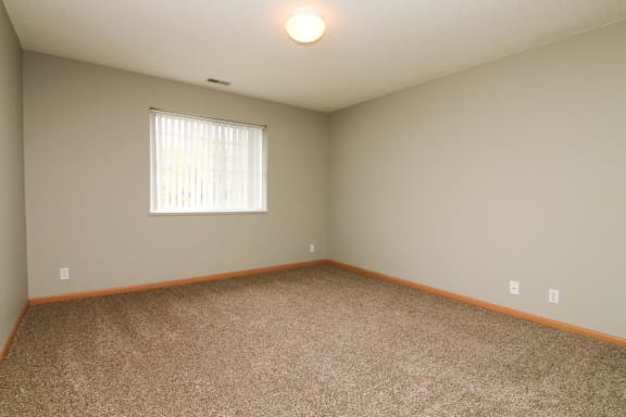 an empty room with carpet and a window