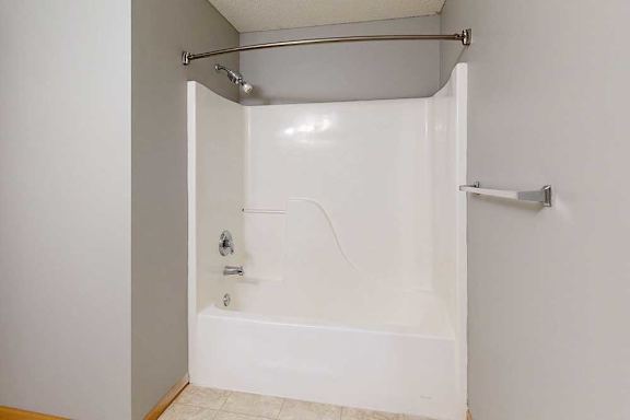 a white bathroom with a tub/shower combo