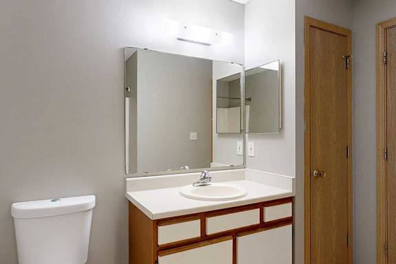 A bathroom with a white sink and white cabinet