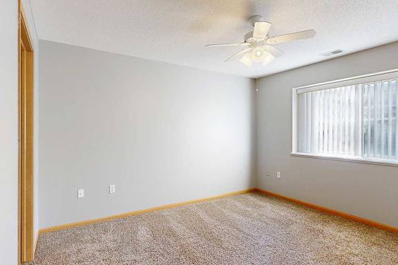 bedroom with a ceiling fan and a window with blinds