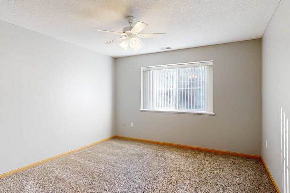 bedroom with a ceiling fan and a window with blinds.