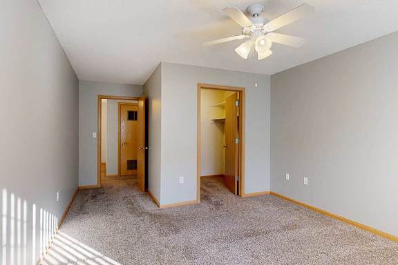 bedroom room with a ceiling fan and walk in closet