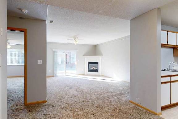 a living room with a fireplace and a ceiling fan