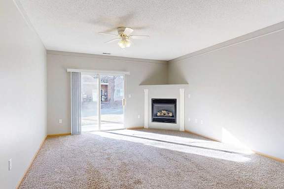 a living room with a fireplace and a ceiling fan