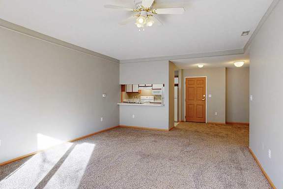 A room with a ceiling fan and a carpeted floor.
