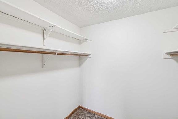 A white wall with a shelf and a white ceiling.