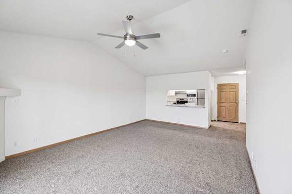 A room with a ceiling fan and carpeted floor.