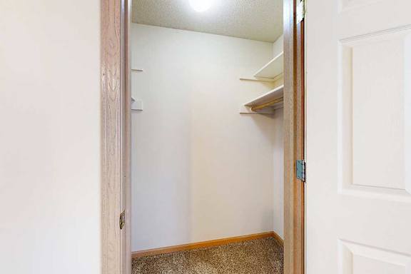 a walk-in closet with built-in overhead shelving and hanging space