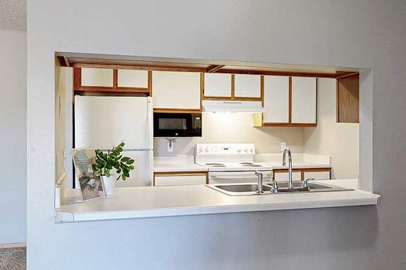 a kitchen with a sink, stove, and microwave.
