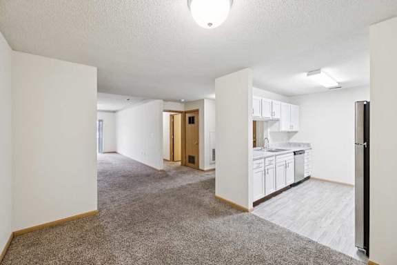 A spacious living area with a kitchen in the background.