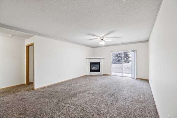 A room with a fireplace and a ceiling fan.