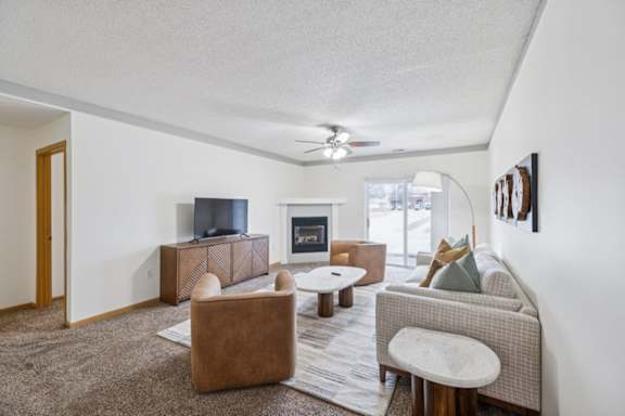 A living room with a brown couch, a brown chair, and a brown rug.