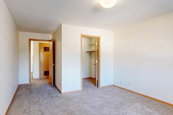 a carpeted bedroom with a walk-in closet