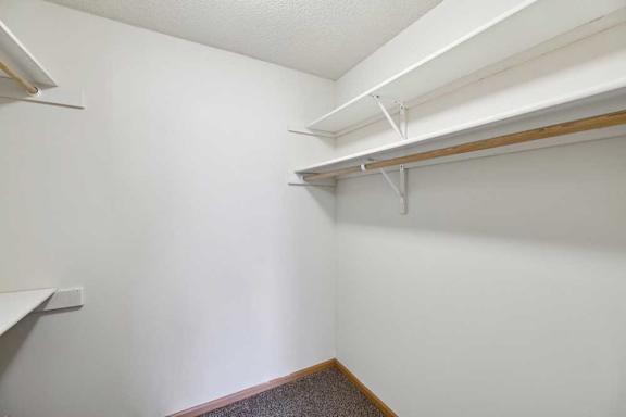 A white wall with a brown floor and a white ceiling.