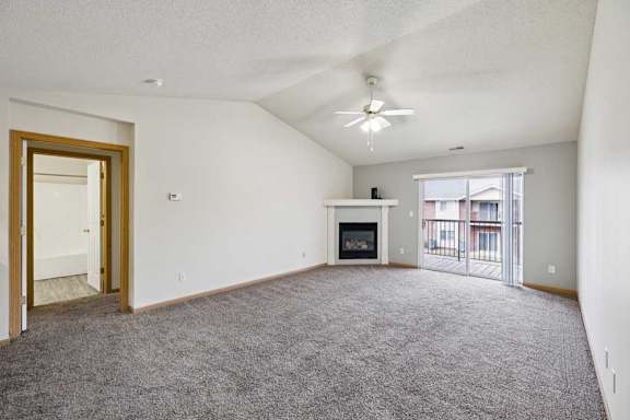 A spacious living room with a fireplace and sliding glass doors.