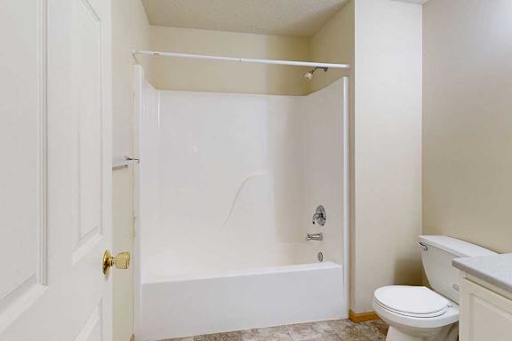 bathroom with bathtub/shower combo and toilet.