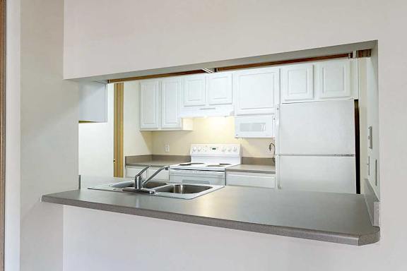 a kitchen with white cabinets and a breakfast bar with seating
