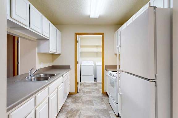 galley kitchen with white appliances and cabinets