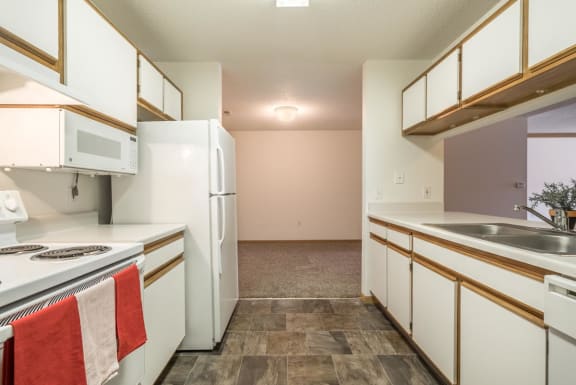 a kitchen with white appliances and a sink and a refrigerator