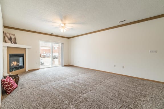 a living room with a fireplace and a carpeted floor