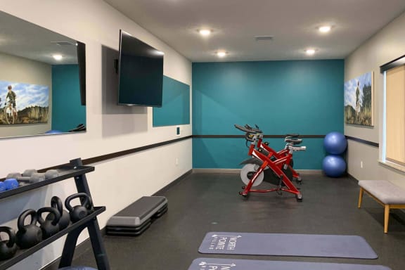 a gym with a red bike and weights on the floor at North Pointe Villas Apartments, Lincoln, 68521