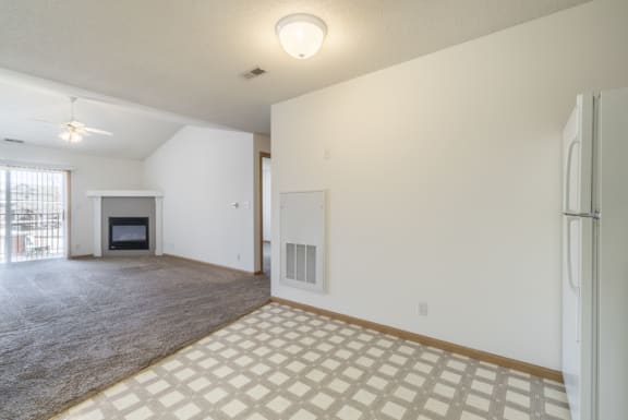 the living room and dining room of an empty house with a fireplace
