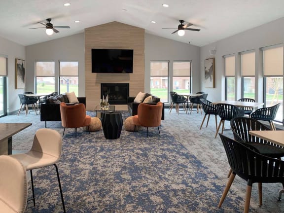 a large living room with chairs and tables and a fireplace