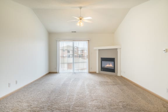 an empty living room with a fireplace and a window