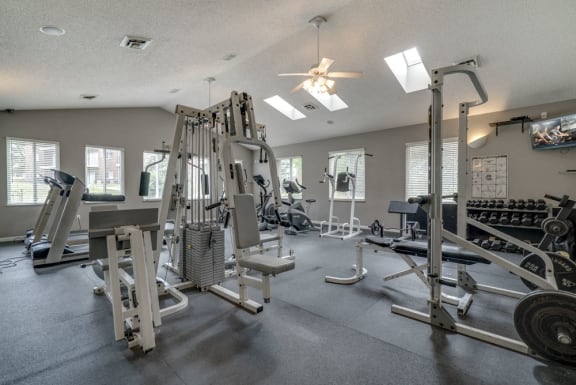 Fitness center with equipment and free weights at Northridge Heights Apartments