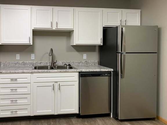 a kitchen with white cabinets and stainless steel appliances