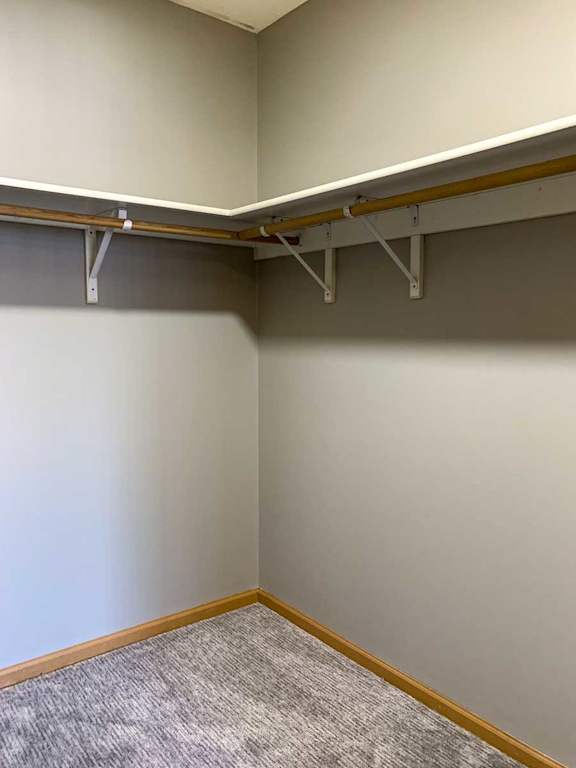 a walk-in closet with built-in shelving and hanging space