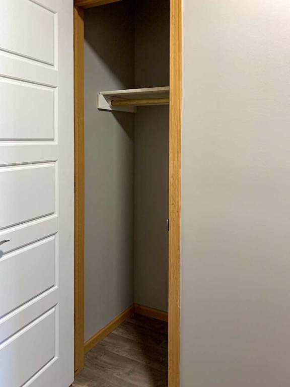 a hallway coat closet with a built-in shelf