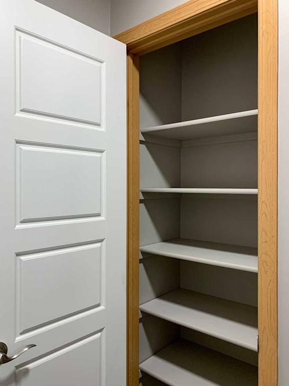 a linen closet with built-in shelves