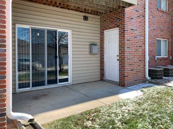 a patio off a brick building with a sliding glass door