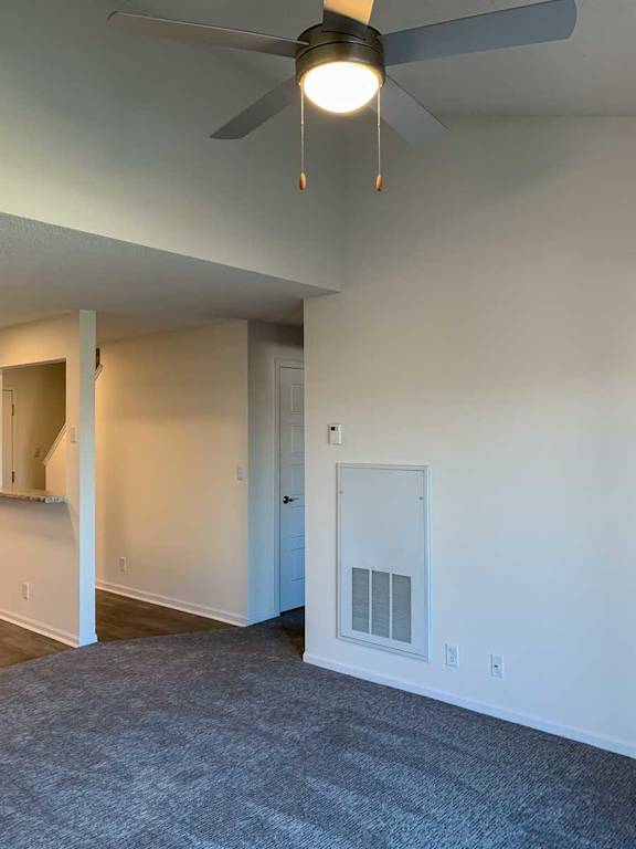 a living room with vaulted ceilings and a ceiling fan