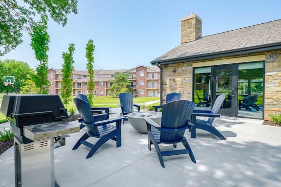 Firepit seating area with cozy chairs and apartment buildings nearby