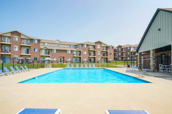 Poolside view with an apartment building in the background