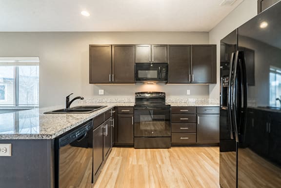 Kitchen with hardwood-like flooring and GE appliances at The Villas of Omaha at Butler Ridge in Omaha Nebraska