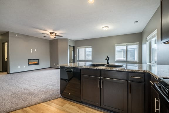 A kitchen that opens up to a large living space at the Villas of Omaha at Butler Ridge in Omaha Nebraska
