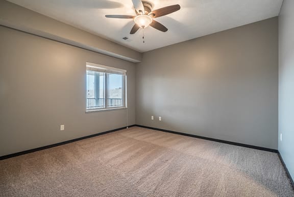 Bedroom with ceiling fan and abundant natural lighting at the Villas of Omaha at Butler Ridge in Omaha Nebraska