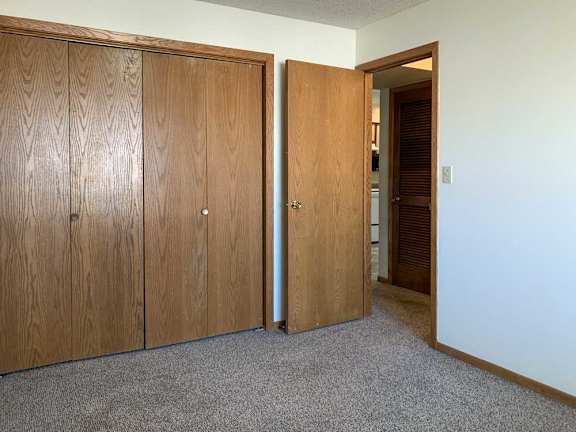 a bedroom with a closed sliding door closet and a door open to the hallway