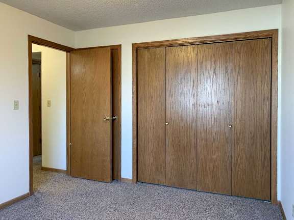 a bedroom with a closed double-door closet