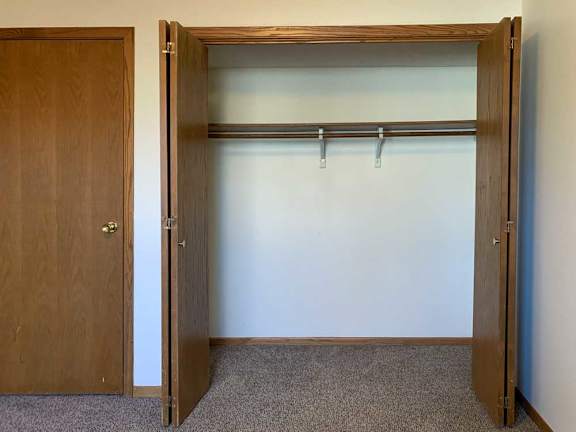a bedroom with a sliding door closet with a built-in shelf