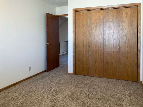 a bedroom with a door open to the loft area and a closed closet